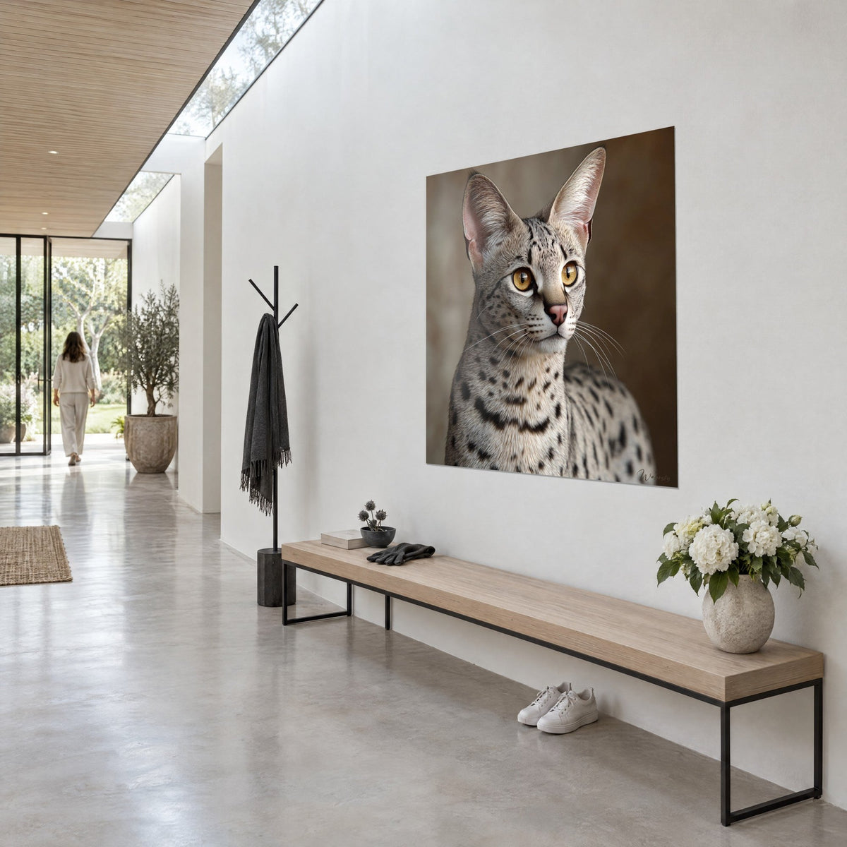 Tableau serval aux grandes oreilles roses, fourrure grise tachetée et regard doré, accroché en vue de trois-quarts dans un couloir