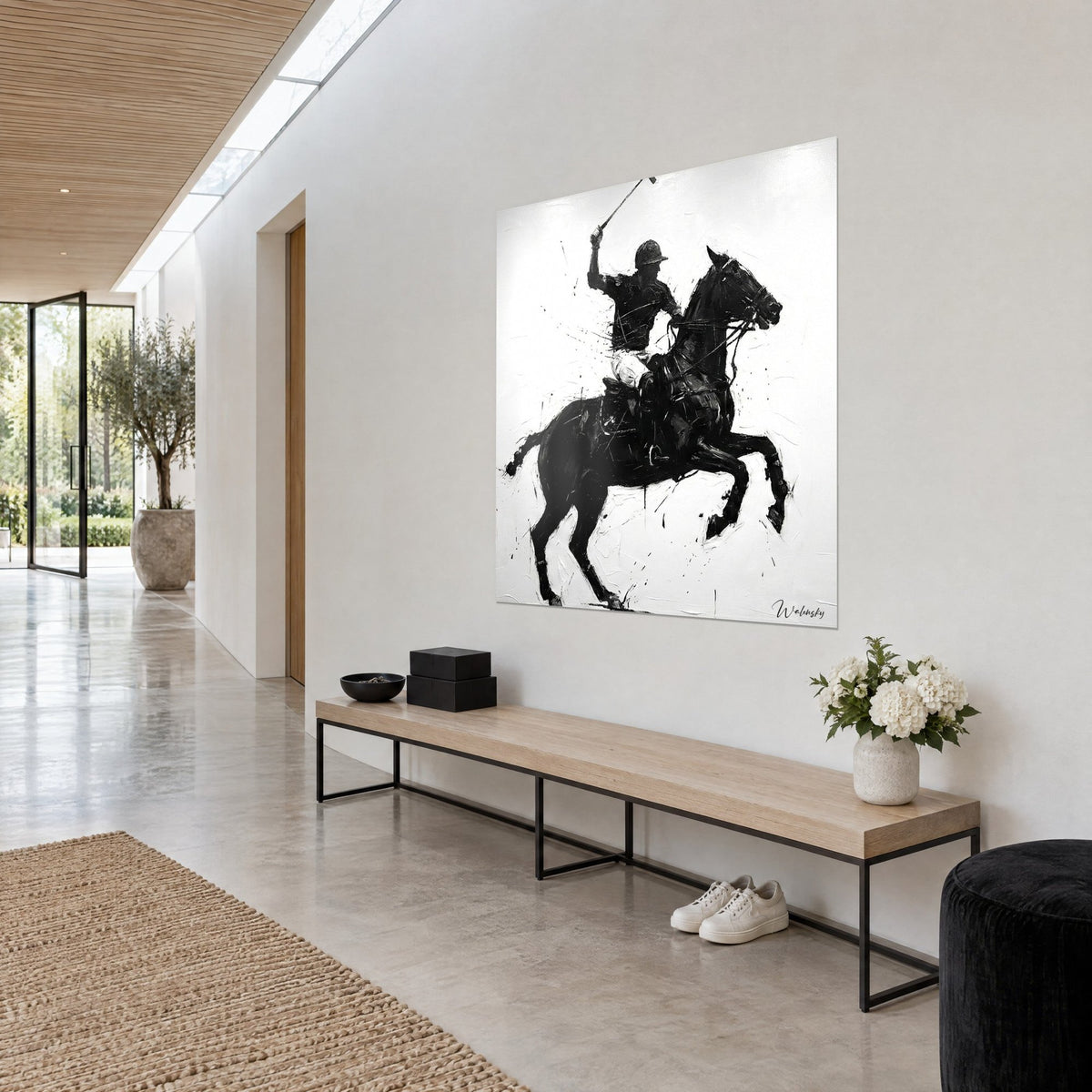 Wall art of a horseman in black ink splashed on white, rearing stallion, hung on the wall of a hallway in an architect's house
