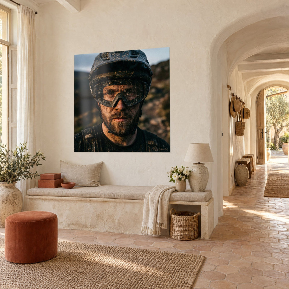 Cuadro retrato de un ciclista barbudo de ojos verdes, casco salpicado de tierra, marrones y ocres, en una masía provenzal