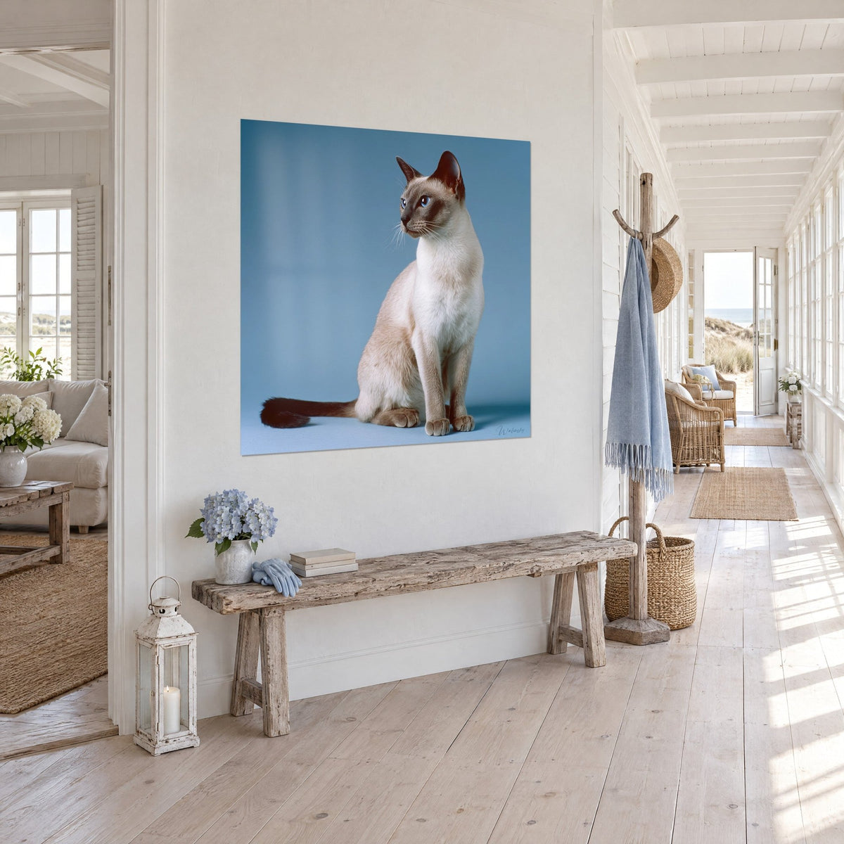Quadro di un felino slanciato dagli occhi azzurri e coda marrone scuro su sfondo azzurro cielo, appeso in un corridoio in legno sbiancato