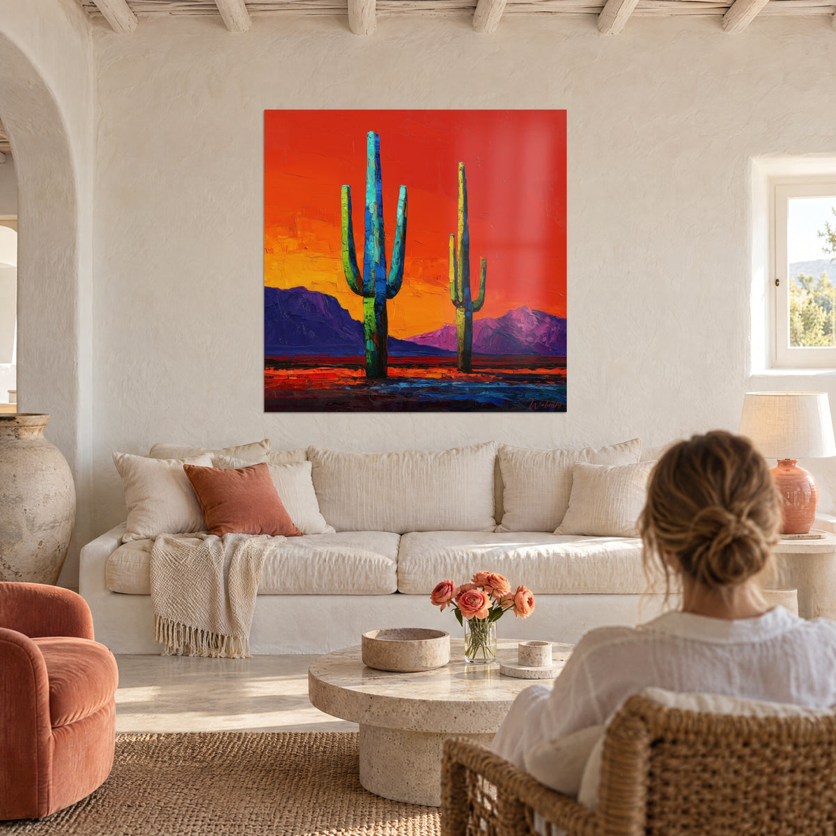 Gemälde Saguaro-Kakteen in Türkisblau unter rotorangefarbenem Himmel, violette Berge, über einem Sofa in einem hellen Wohnzimmer