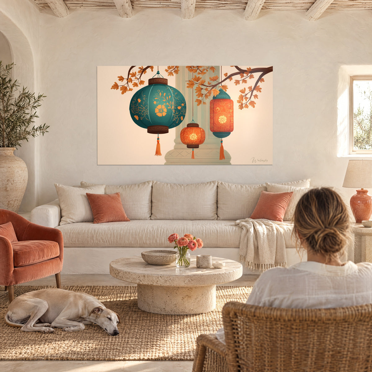 Wall art of turquoise and orange paper lanterns beneath autumn branches, above a sofa in a bright living room