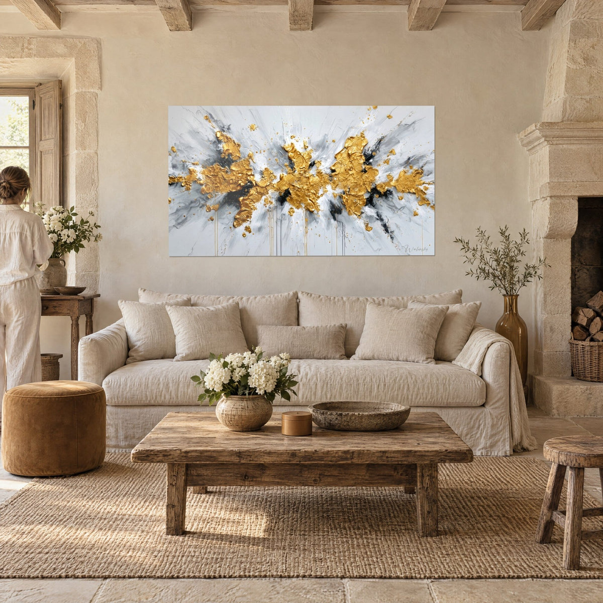 Wall art golden relief explosion on white and grey background, seen from behind by a woman, above a sofa in a bright living room