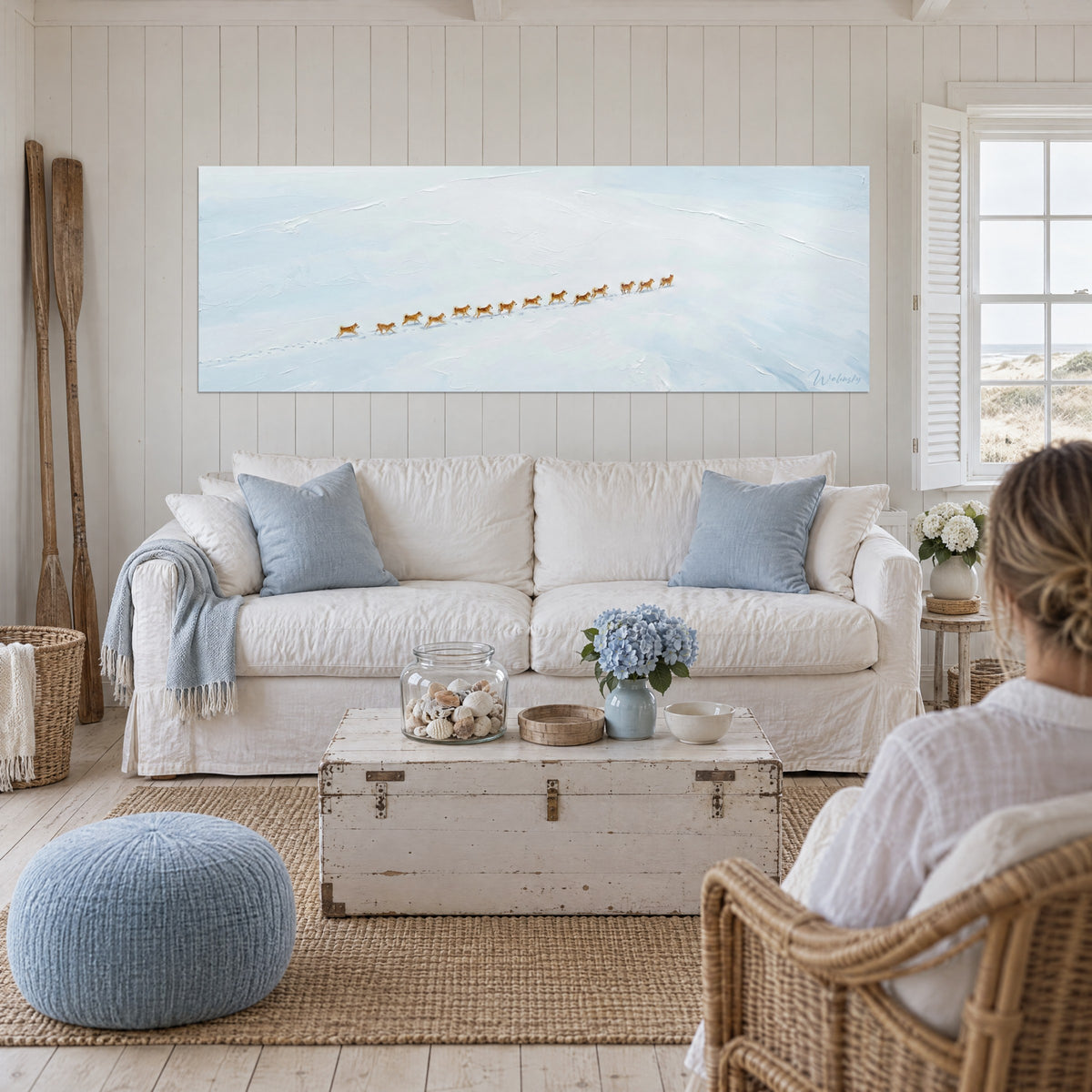 Gemälde Akita-Meute in Reihe im Schnee, rotbraunes Fell und eisig blauer Hintergrund, über einem Sofa in einem hellen Wohnzimmer