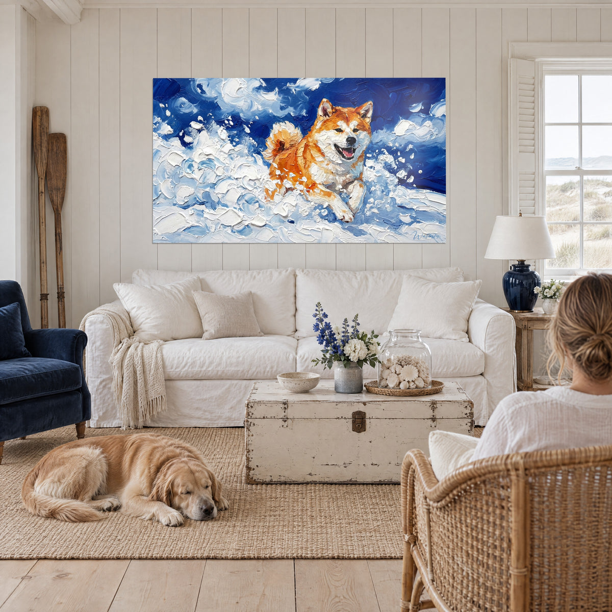 Gemälde Akita Inu rotbraun springend im blauen Pulverschnee, zwei Personen von hinten und ein Retriever, über einem Sofa in einem hellen Wohnzimmer