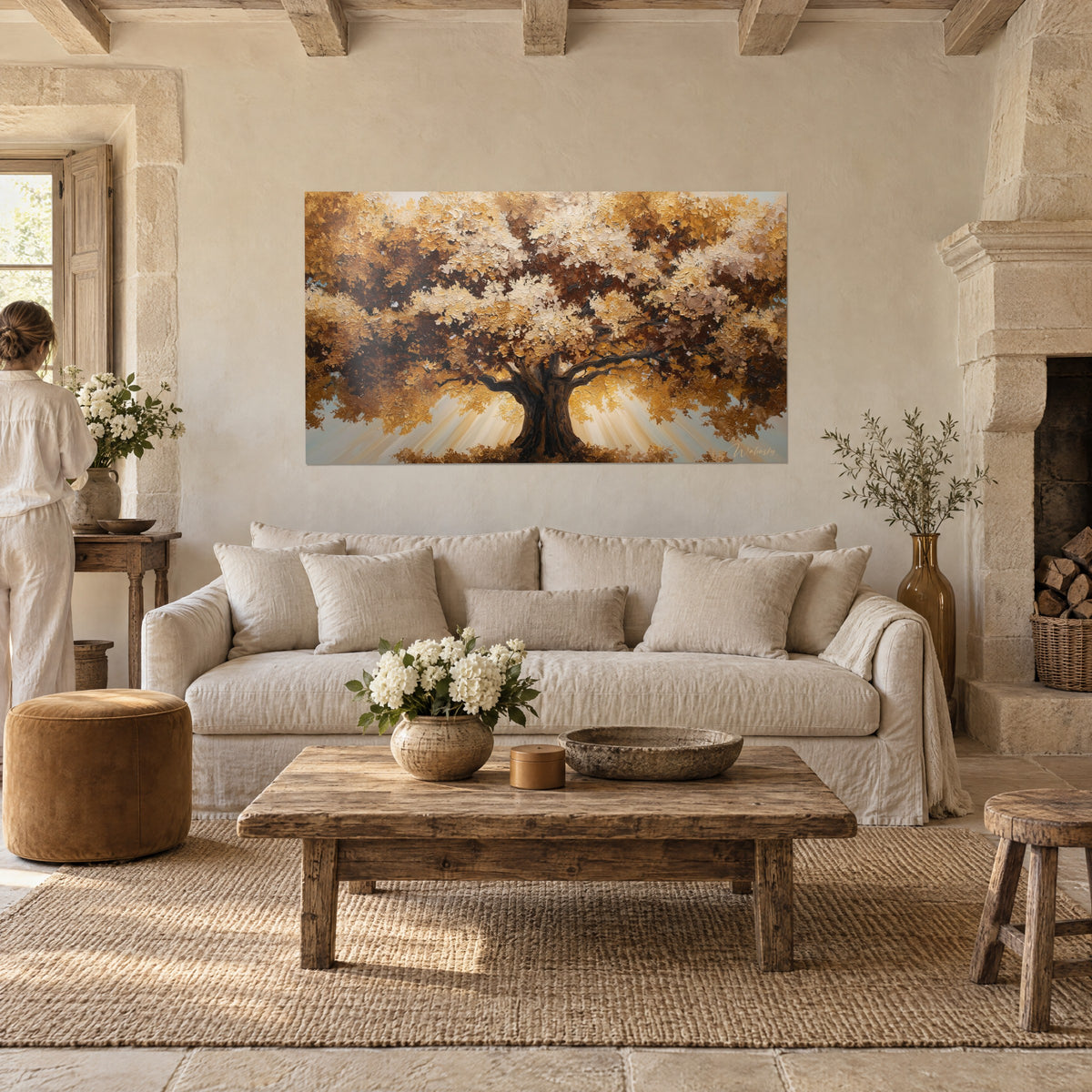 Wall art of a centuries-old oak with sprawling branches, ochre and coppery brown foliage, golden light rays, above a sofa in a bright living room