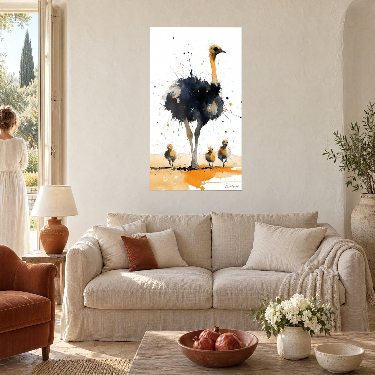 Gemälde Strauß mit nachtblauem Gefieder und safrangelbem Hals, drei ockerfarbene Küken auf orangefarbenem Sand, über einem Sofa in einem hellen Wohnzimmer