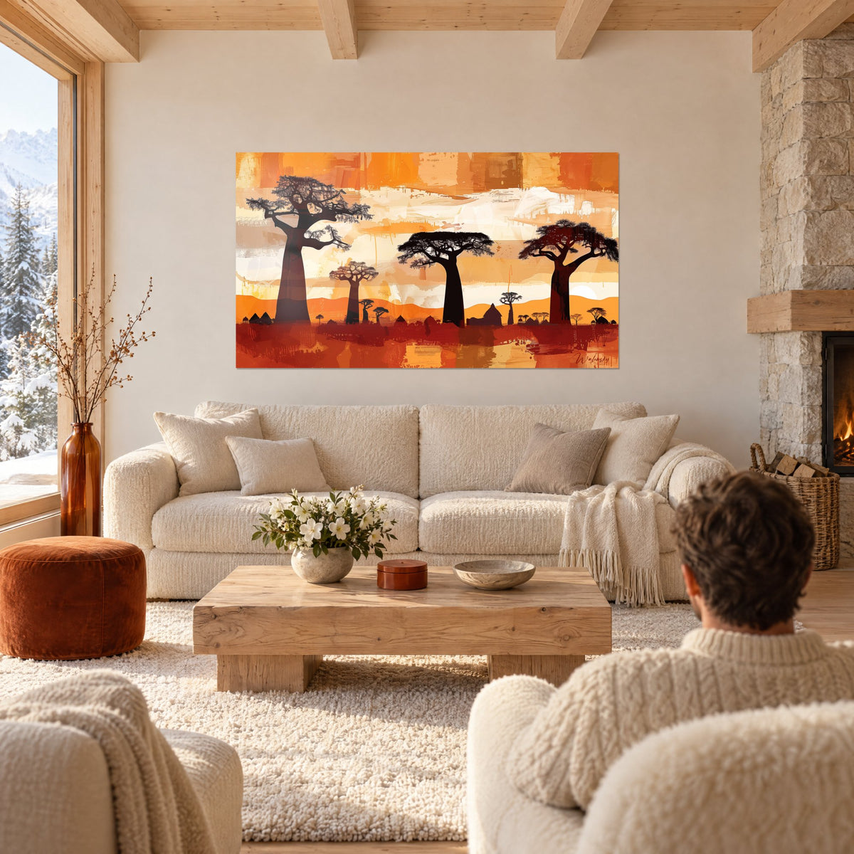 Tableau trois baobabs en ombre chinoise sur ciel orangé et ocre, homme de dos, au-dessus d'un canapé dans un salon lumineux