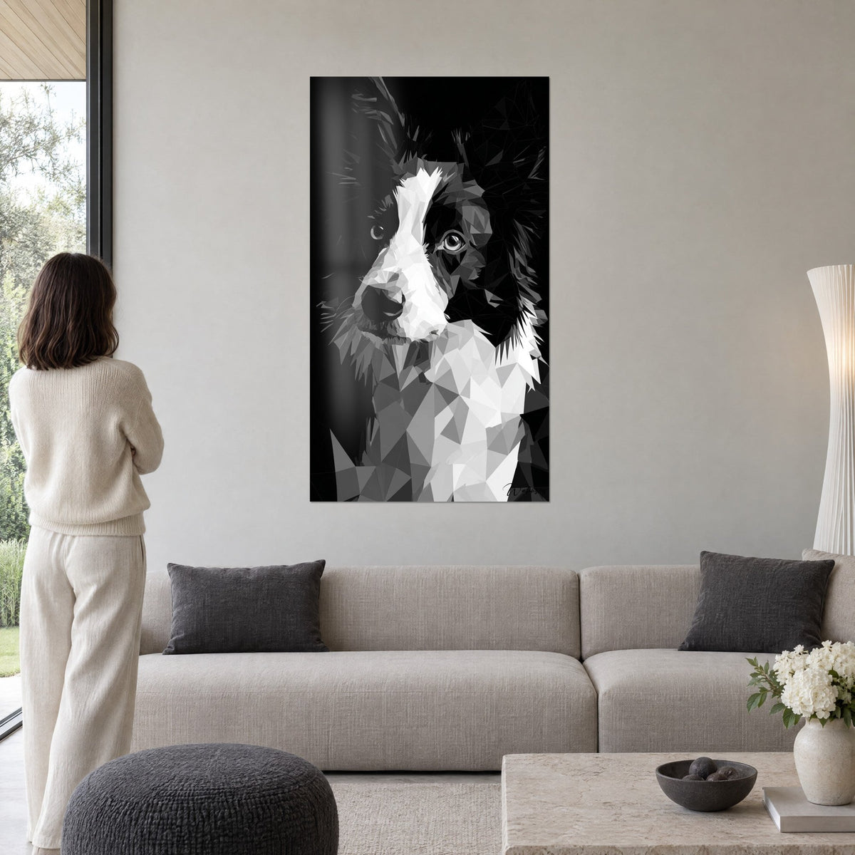 Obraz Border Collie w czarno-białych wielokątnych facetach, jasny pysk i bursztynowe spojrzenie, nad kanapą w jasnym salonie