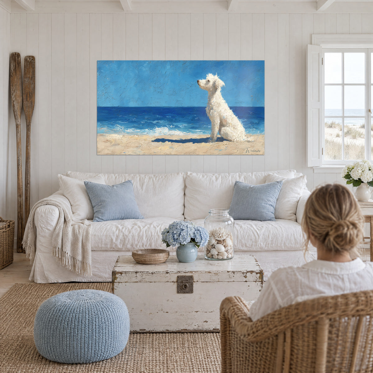 Quadro di un barboncino bianco riccio seduto di fronte all'oceano blu, sabbia dorata, pasta spessa, sopra un divano in un soggiorno luminoso