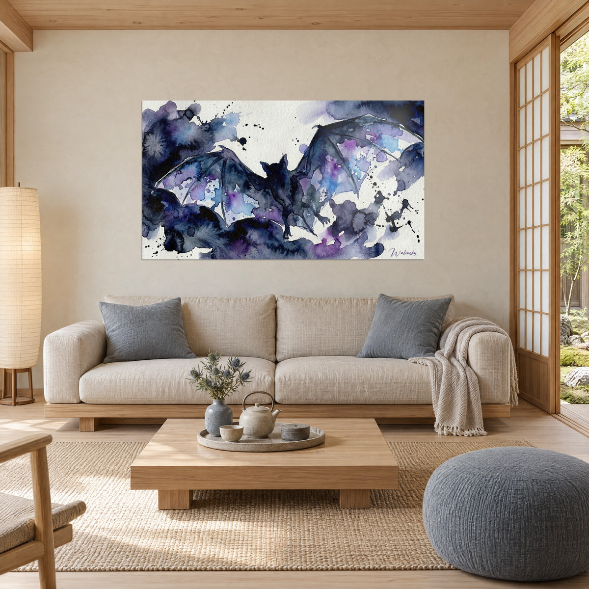 Gemälde Fledermaus mit ausgebreiteten Flügeln, Aquarell in Nachtblau und Violett, Tintenspritzer, über einem Sofa in einem hellen Wohnzimmer
