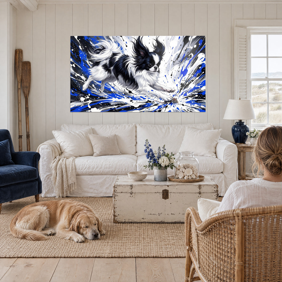 Gemälde eines schwarz-weißen japanischen Spaniels, springend zwischen blauen Spritzern, über einem Sofa in einem hellen Wohnzimmer