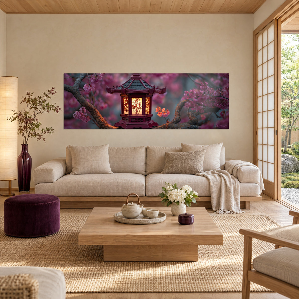 Quadro di una lanterna giapponese dai vetri ambrati su un ramo di ciliegio rosa, bordeaux e fucsia, sopra un divano in un soggiorno luminoso
