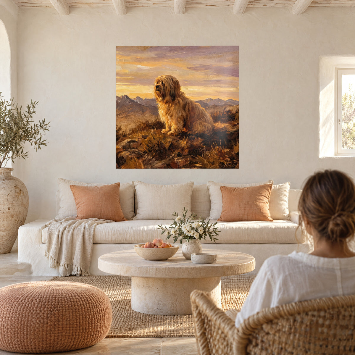 Tableau Lhassa Apso à longue robe dorée, assis face aux montagnes violettes d'un ciel ambre, au-dessus d'un canapé dans un salon lumineux