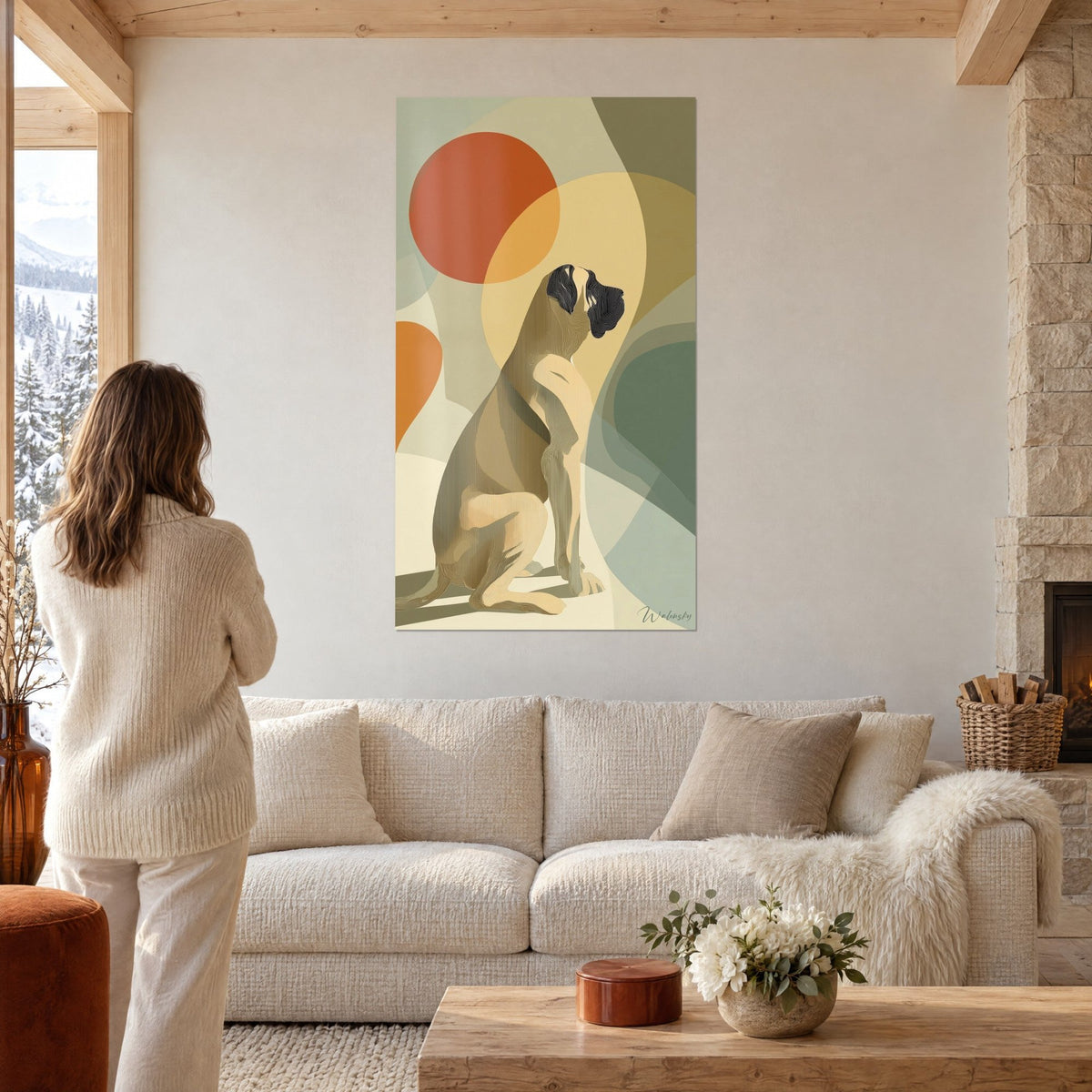 Tableau mastiff assis aux courbes ocre et vert sauge, soleil rouille au-dessus, une femme de dos, au-dessus d'un canapé dans un salon lumineux