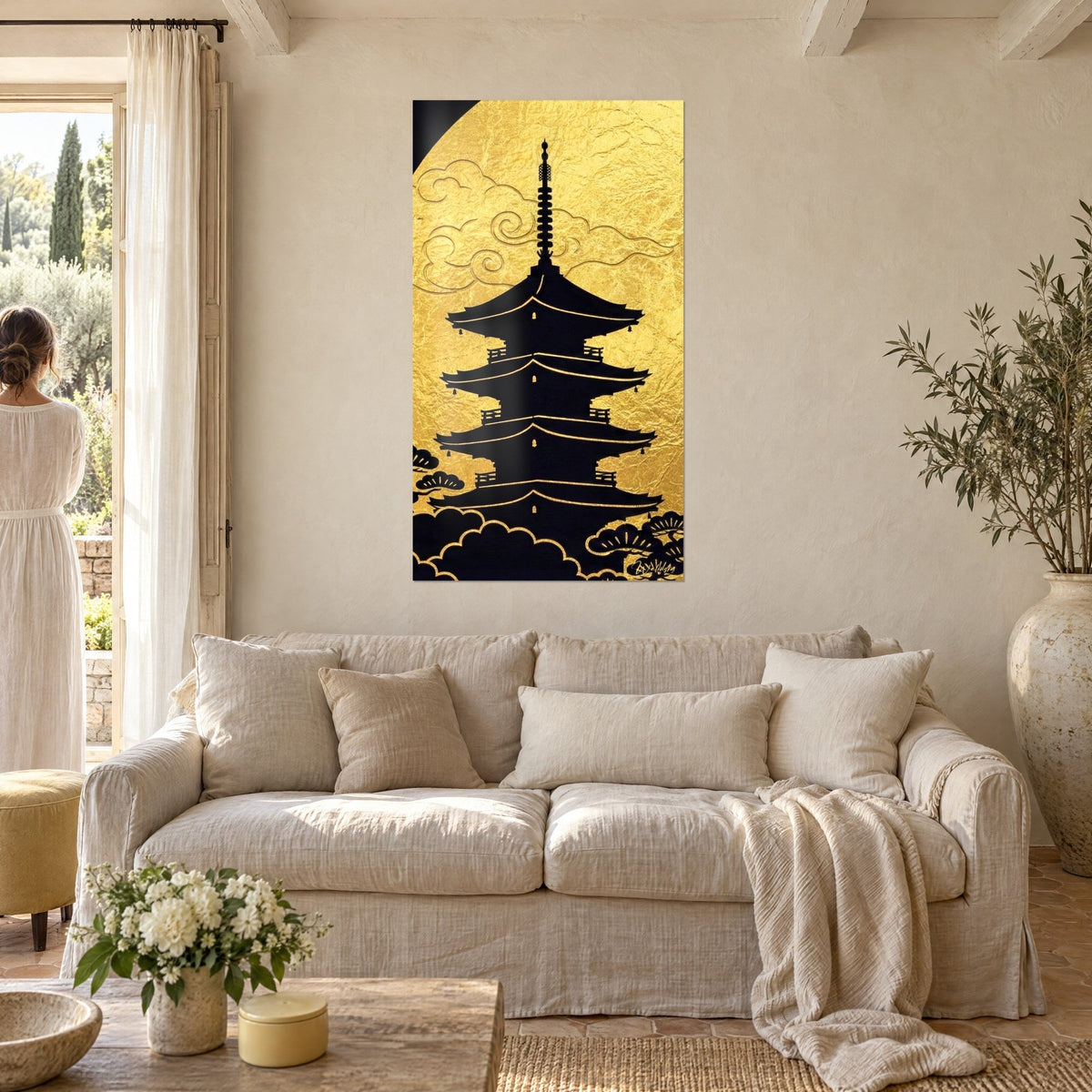Tableau pagode noire à cinq toits sur feuille d'or froissée, spirales de nuages gravées, au-dessus d'un canapé dans un salon lumineux
