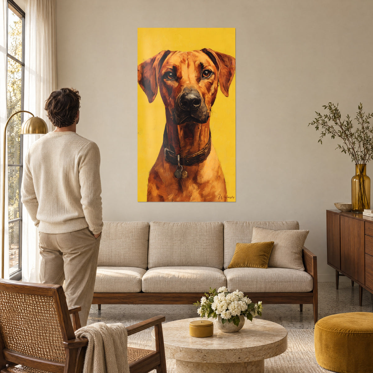 Obraz Rhodesian Ridgeback o bursztynowym spojrzeniu, rudej sierści i brązowej obroży na żółtym tle, nad sofą w jasnym salonie