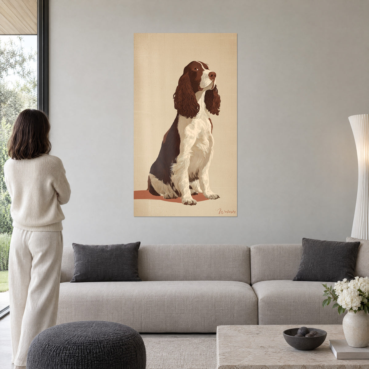 Cuadro de un spaniel sentado marrón y blanco con orejas rizadas caoba, fondo beige, sobre un sofá en un salón luminoso