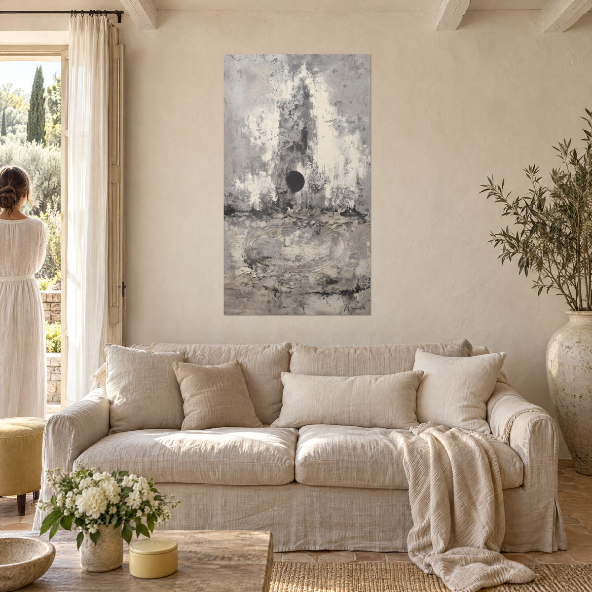 Gemälde abstrakt in Grau und Schwarz, dunkle Scheibe auf abgeblättertem cremeweißem Putz, eingeritzte Spirale, über einem Sofa in einem hellen Wohnzimmer