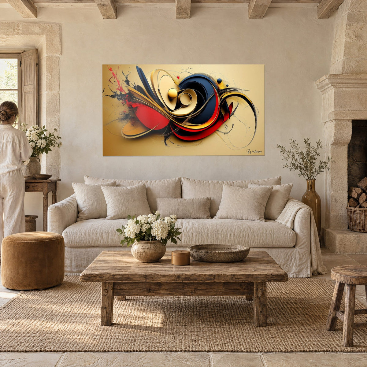 Tableau abstrait de volutes rouges, bleu nuit et or sur fond sable, une femme de dos, au-dessus d'un canapé dans un salon lumineux