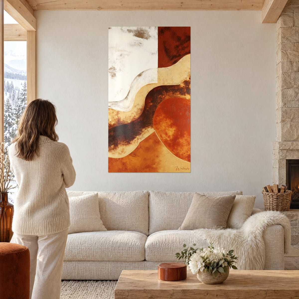Quadro di forme fluide in terra di Siena e ocra, curve crema e ruggine, donna di spalle, sopra un divano in un soggiorno luminoso