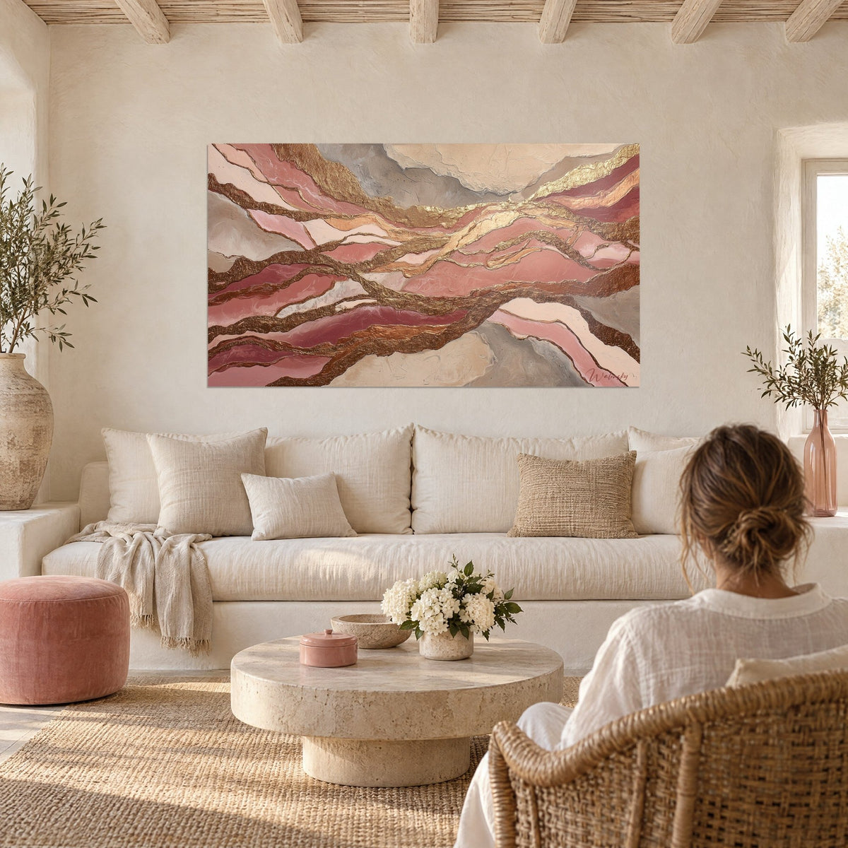 Cuadro abstracto con venas doradas onduladas sobre fondo rosa polvo y gris, colgado encima de un sofá en un salón luminoso