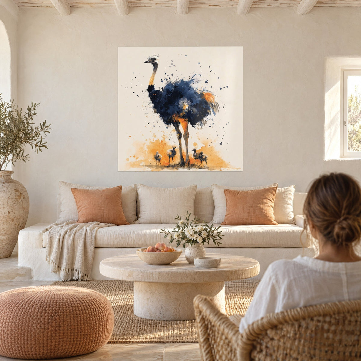 Gemälde Strauß mit indigoblauem Gefieder und orangefarbenen Beinen, unten drei flauschige Küken, über einem Sofa in einem hellen Wohnzimmer