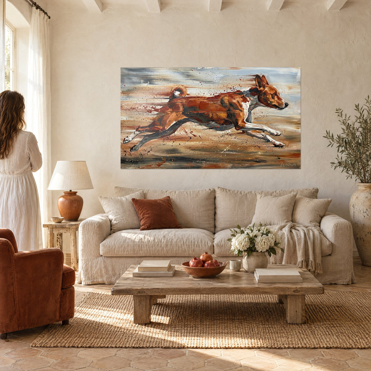 Gemälde eines rothaarigen Windhunds, der über ockerfarbenem und grauem Grund springt, Ölmalerei, Rückenansicht einer Frau, über einem Sofa in einem hellen Wohnzimmer