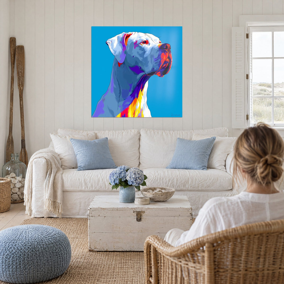 Tableau dogue blanc au museau rouge et violet, fond turquoise, aux murs d'un salon marin, au-dessus d'un canapé dans un salon lumineux