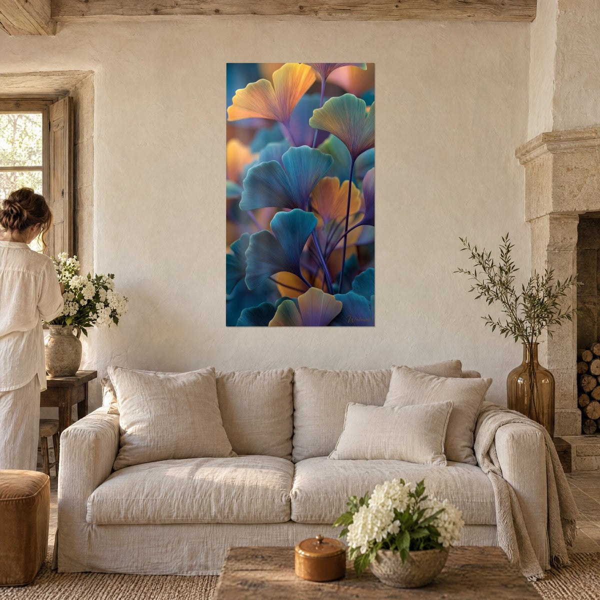 Tableau feuilles de ginkgo turquoise et orangées en éventail, nervures fines, une femme de dos, au-dessus d'un canapé dans un salon lumineux
