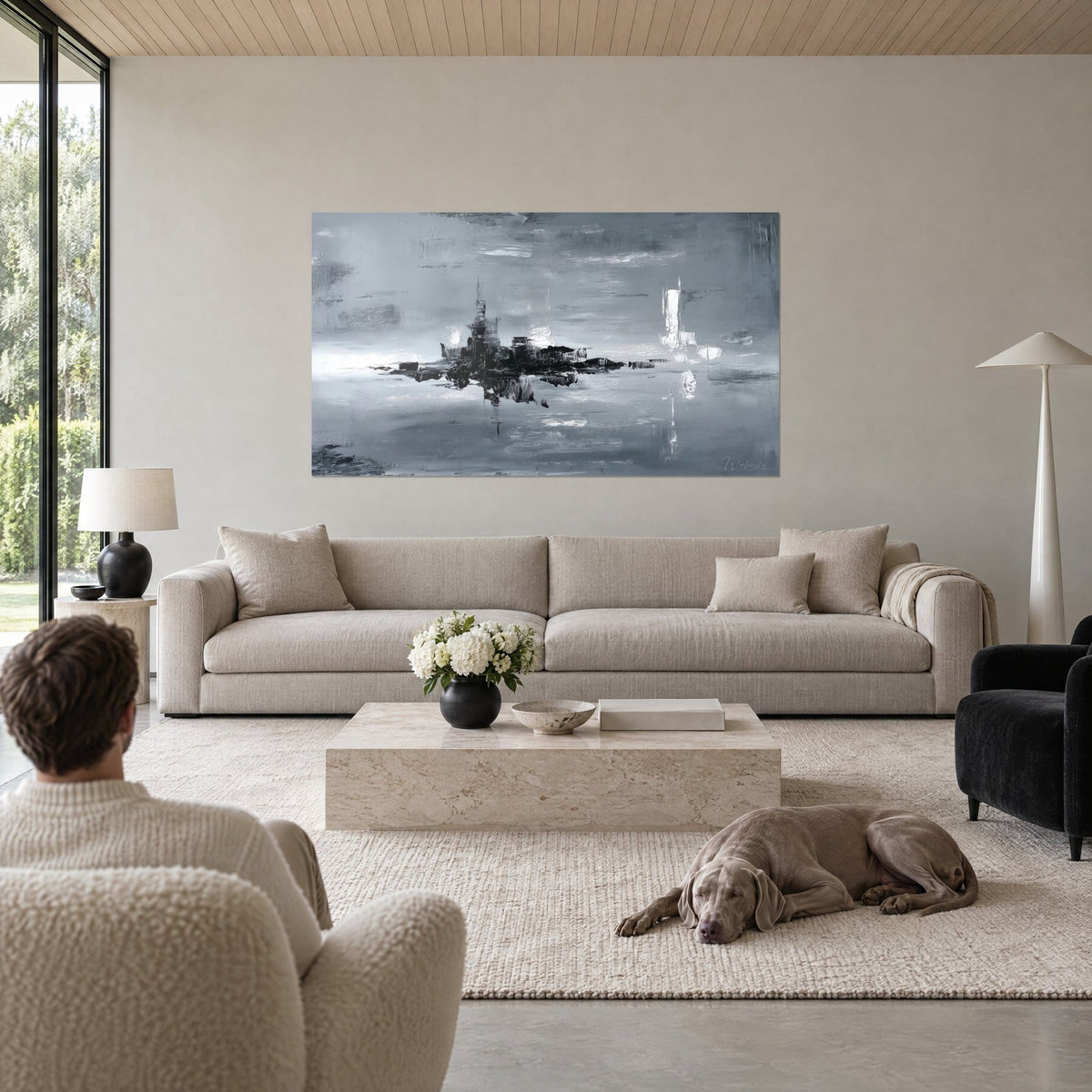 Gemälde mit schwarzer Stadtsilhouette im grauen Dunst, weiße Spiegelungen im Wasser, über einem Sofa in einem hellen Wohnzimmer