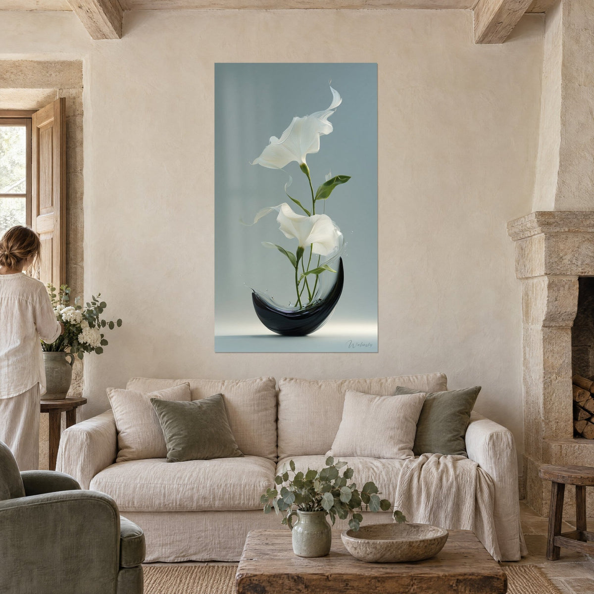 Tableau lys blancs en ikebana dans un vase noir lunaire sur fond gris-bleu, au-dessus d'un canapé dans un salon lumineux