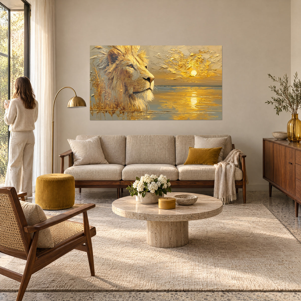 Wall art of a lion with a golden, thickly textured mane gazing at a golden sun over grey water, woman seen from behind, above a sofa in a bright living room