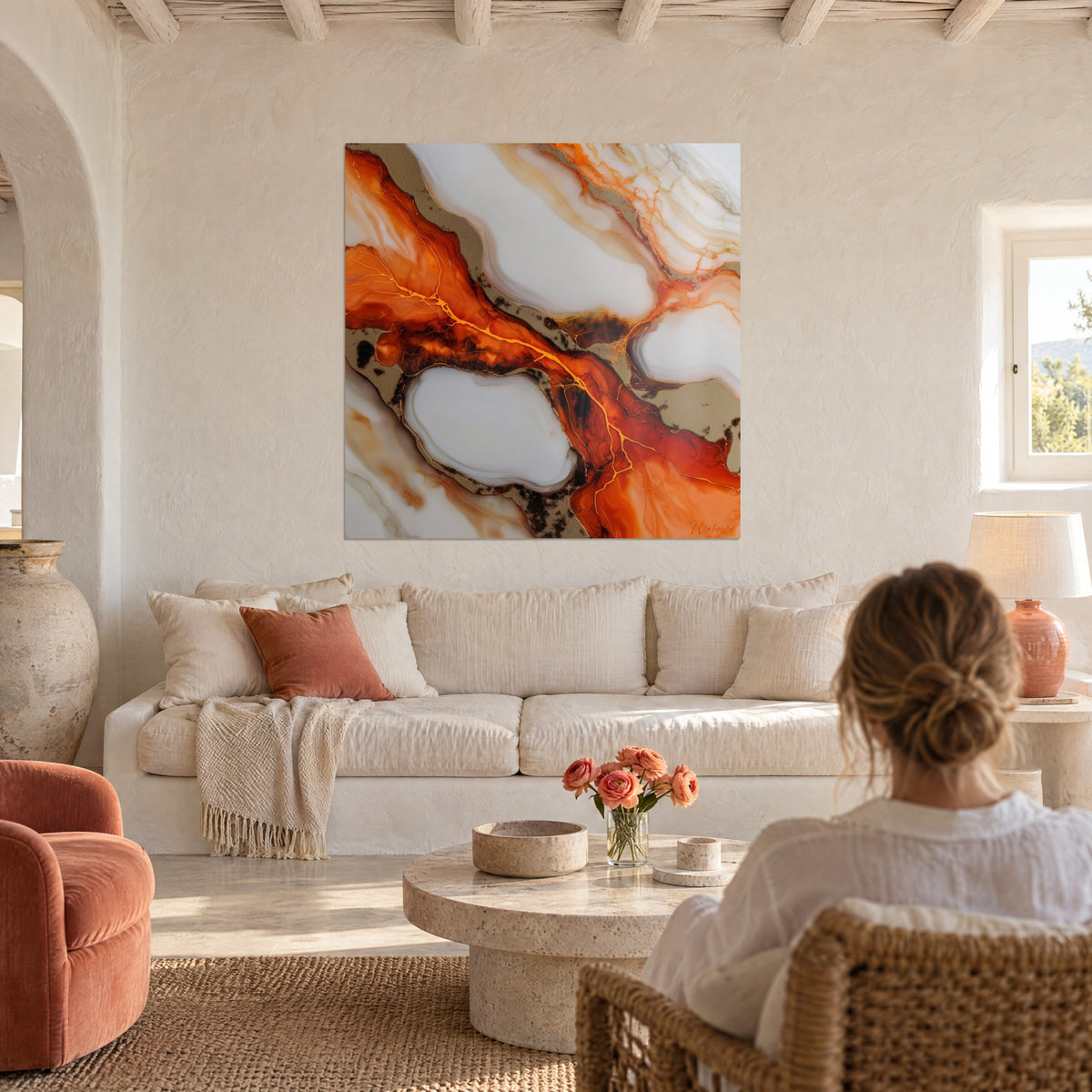 Schilderij met een vlammend oranje stroom doorlopen door gouden lijnen op een parelmoerwit achtergrond, vrouw van achteren, boven een bank in een lichte woonkamer