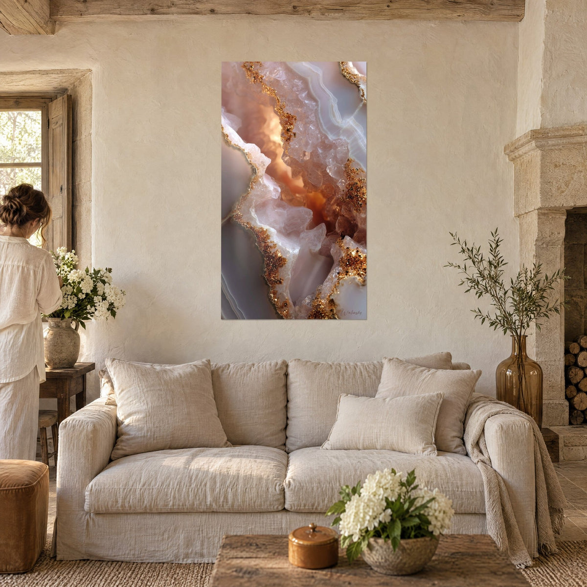 Tableau géode d'agate aux veines dorées, quartz rose et cœur ambré lumineux, une femme de dos au-dessus d'un canapé dans un salon lumineux