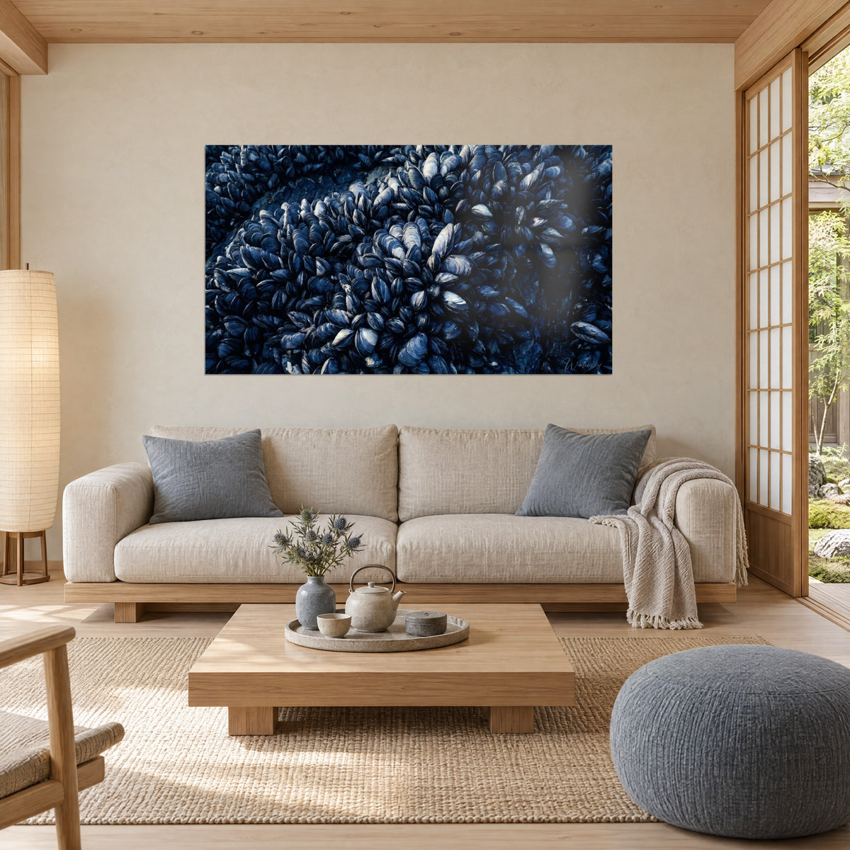 Schilderij tros blauwe mosselen op een rots, indigokleurige schelpen met zilveren glans, boven een bank in een lichte woonkamer
