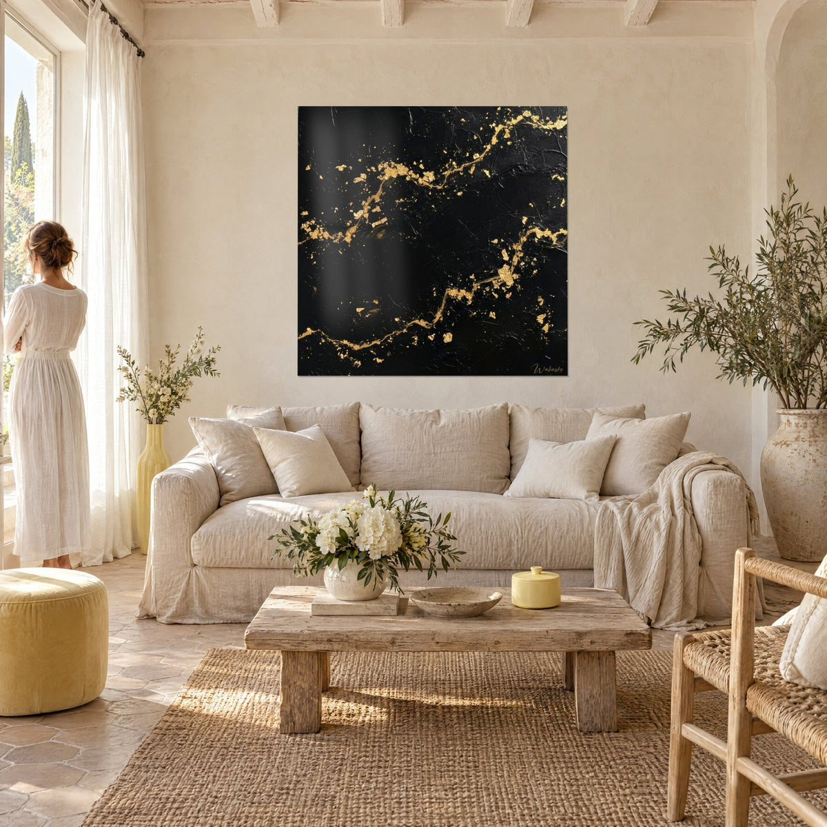 Tableau veines d'or sinueuses sur fond noir mat, éclats dorés, vu par une femme de dos au-dessus d'un canapé dans un salon lumineux