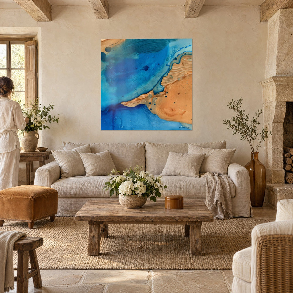 Tableau rivage doré fendant des eaux bleu cobalt, couple de dos, au-dessus d'un canapé dans un salon lumineux