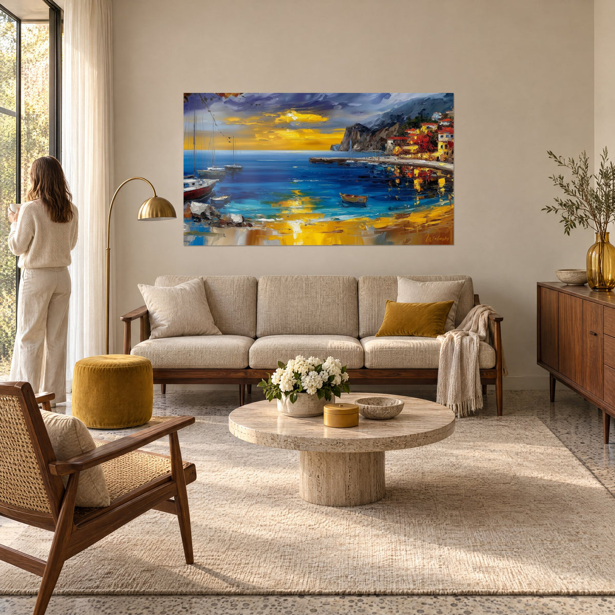 Tableau crique dorée à la peinture au couteau, mer bleu profond et falaise grise, au-dessus d'un canapé dans un salon lumineux