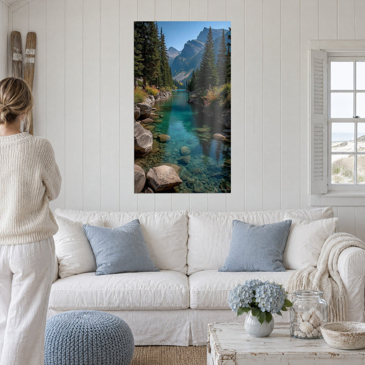 Tableau rivière de montagne aux eaux turquoise bordée de sapins verts, au-dessus d'un canapé dans un salon lumineux