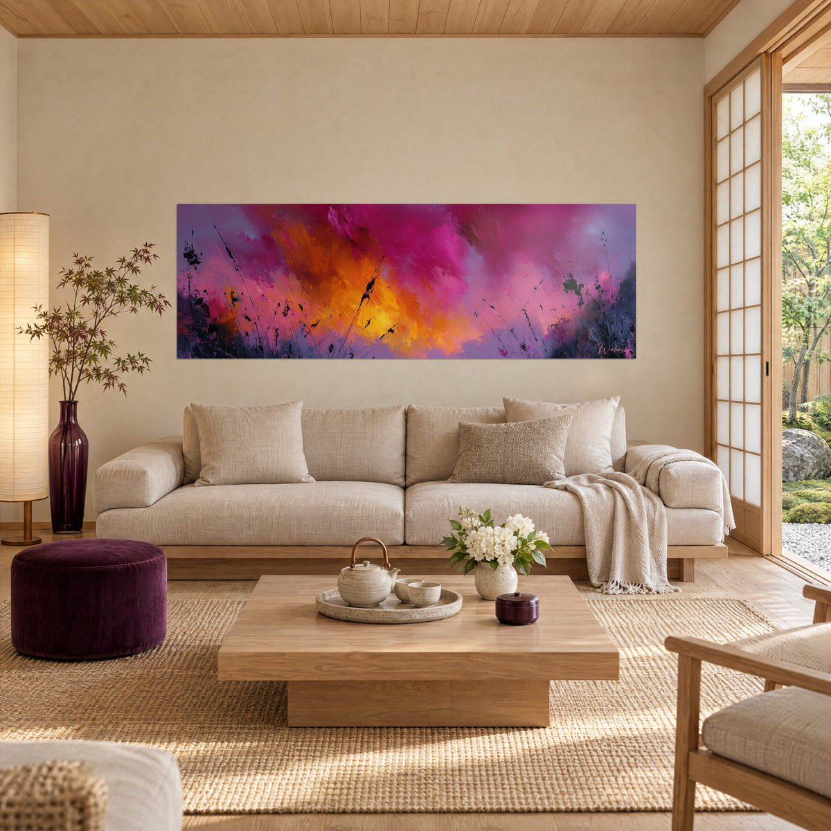 Schilderij met een fuchsia en gloeiend oranje wolkenformatie op paarse ondergrond, zwarte grassen in silhouet, boven een bank in een lichte woonkamer