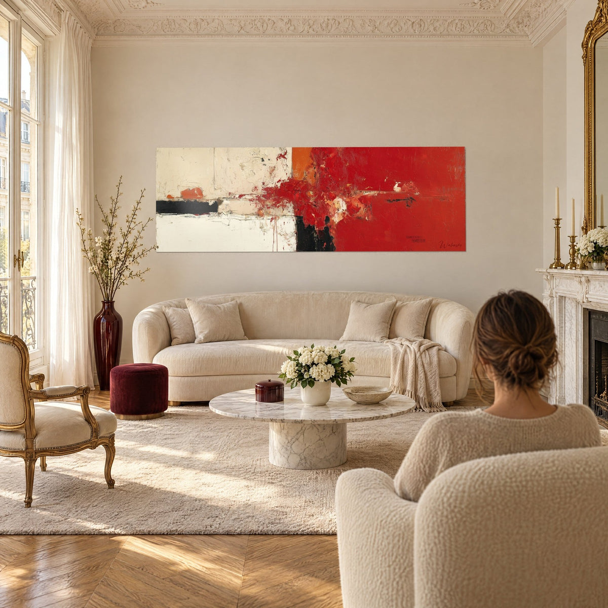Gemälde abstrakt scharlachrot spritzend auf cremefarbenem Grund, schwarze und orangefarbene Streifen, Frau von hinten, über einem Sofa in einem hellen Wohnzimmer