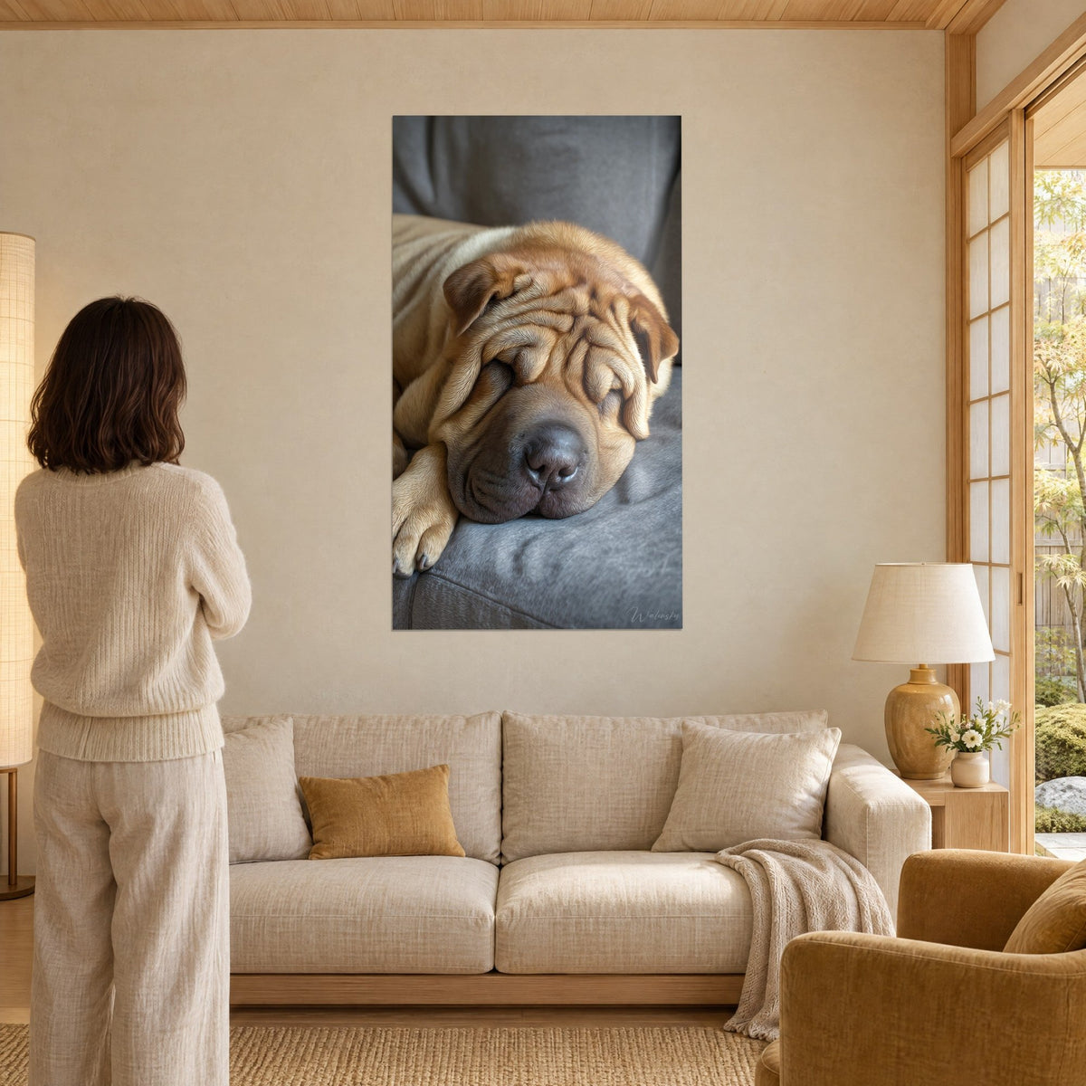 Cuadro de un shar pei dormido con arrugas doradas y hocico gris, sobre una pared beige encima de un sofá en un salón luminoso