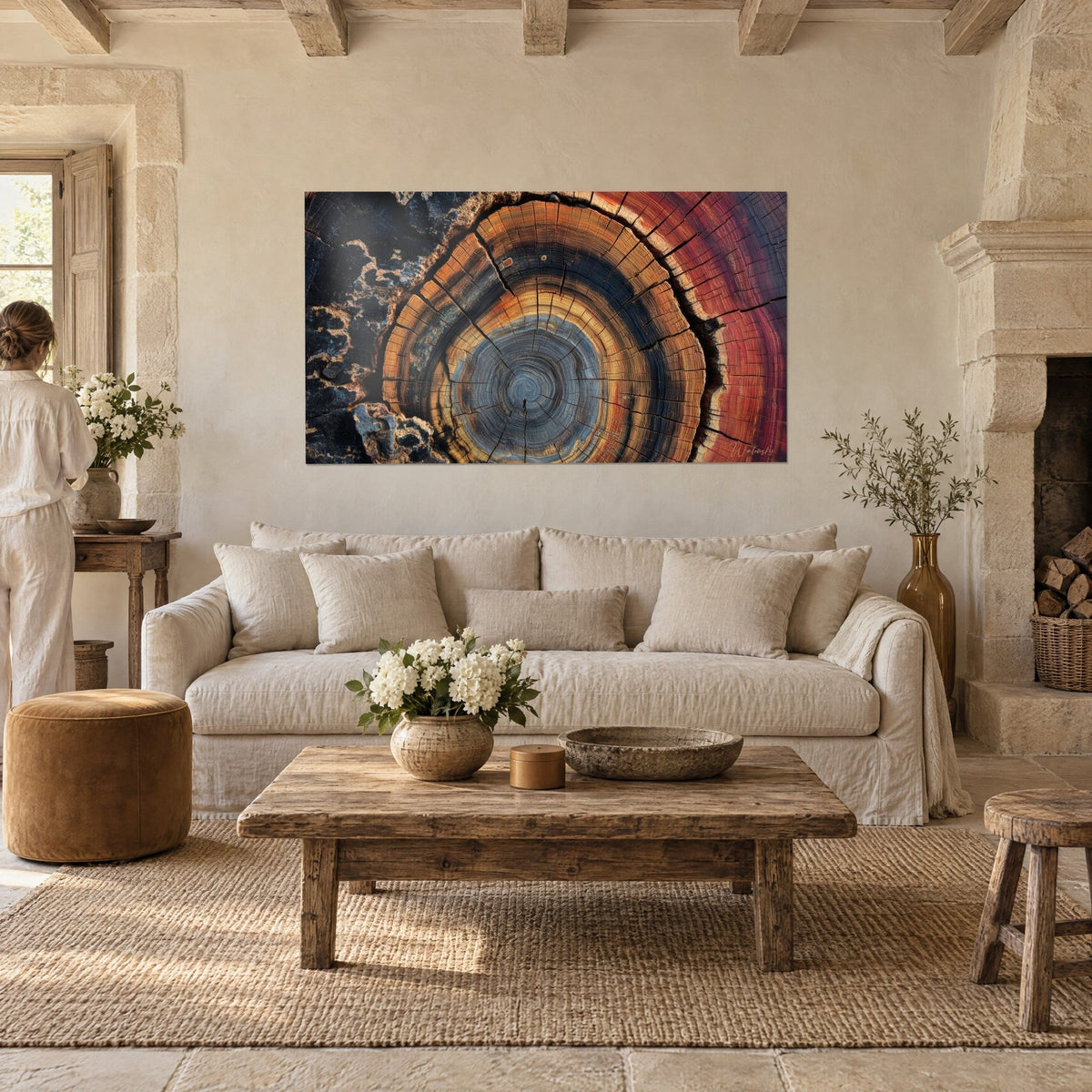Gemälde Baumstammscheibe mit orangefarbenen und stahlblauen Jahresringen, schwarze Risse, rote Ränder, über einem Sofa in einem hellen Wohnzimmer