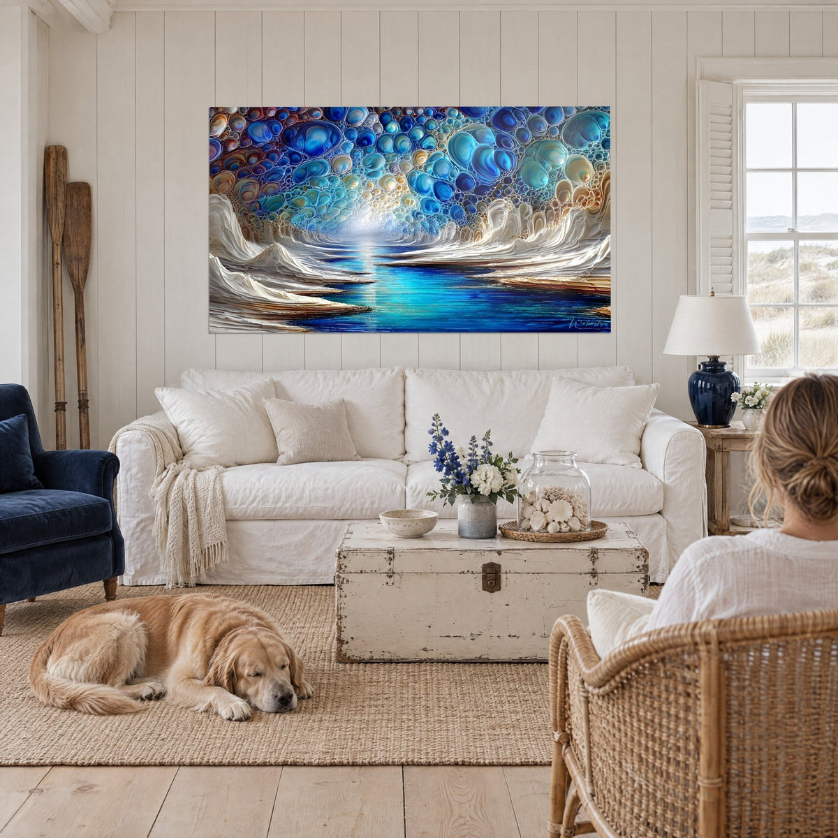 Tableau vague nacrée sculptée en crème, bulles bleu cobalt et turquoise, personne de dos, retriever, au-dessus d'un canapé dans un salon lumineux