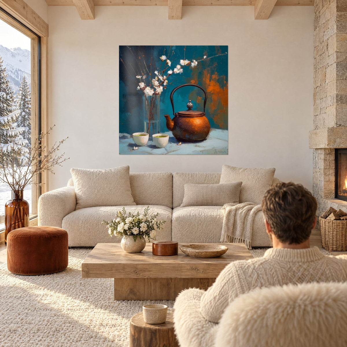 Quadro teiera in ghisa color rame e rami bianchi in fiore su fondo turchese, coppia di spalle, sopra un divano in un soggiorno luminoso