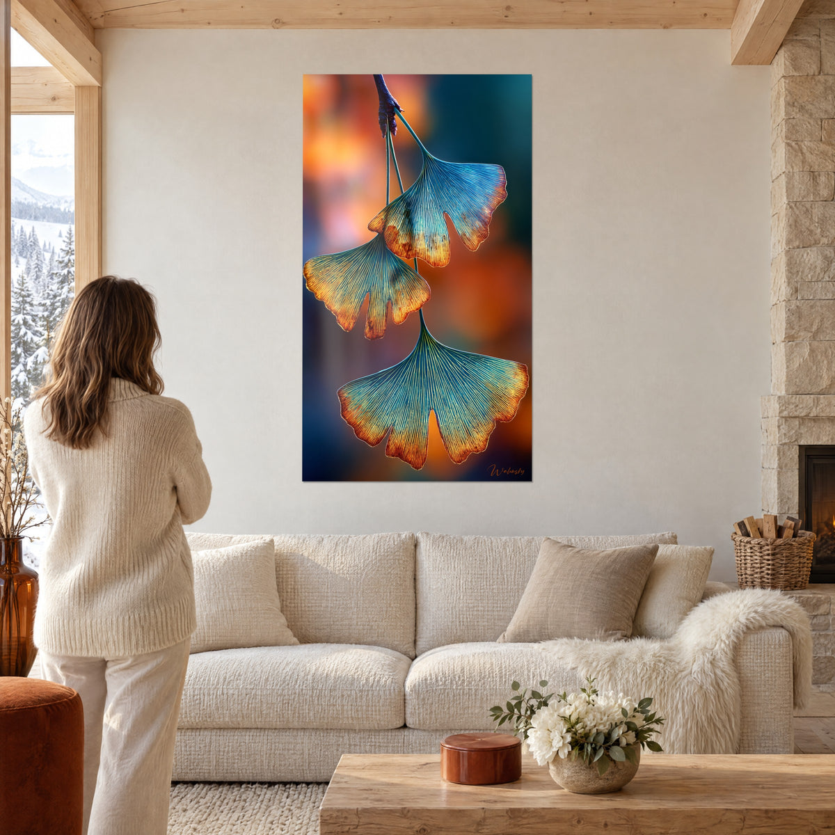 Quadro foglie di ginkgo turchese e oro, donna di spalle, sopra un divano in un soggiorno luminoso