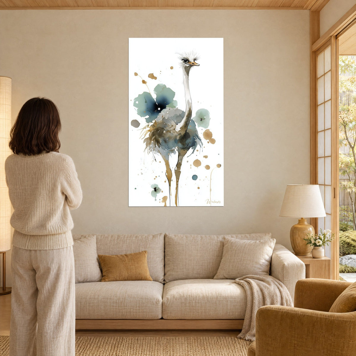 Tableau autruche au long cou blanc et plumage bleu-vert tacheté d'ocre, femme de dos, au-dessus d'un canapé dans un salon lumineux