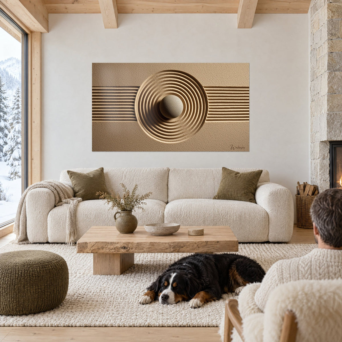Wall art with concentric circles carved into beige and golden sand, light pebble at the centre, above a sofa in a bright living room