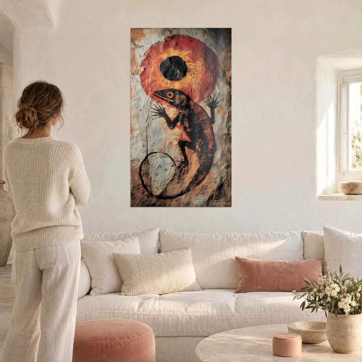 Tableau lézard noir sur disque rouge orangé, éclipse ocre et queue en spirale, au-dessus d'un canapé dans un salon lumineux
